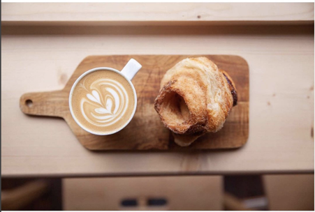 flat_white_and_pastry_on_wooden_board