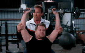 Two men doing a work out. One is helping the other on his fitness journey.